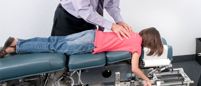 chiropractor adjusting a child